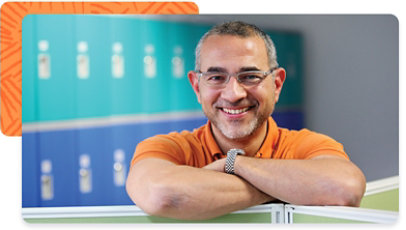 Smiling person leaning on top of an office divider