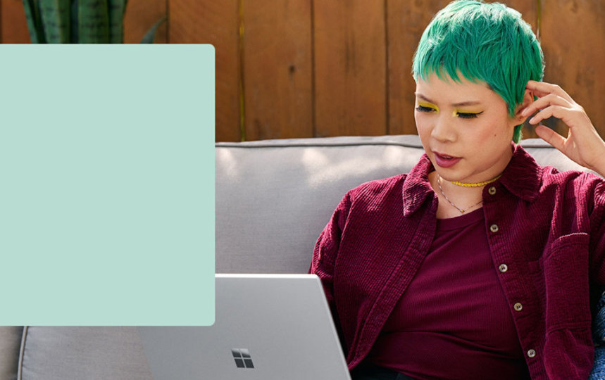 A person sitting on a couch while working on a laptop