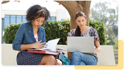 Two people sitting outside, studying together