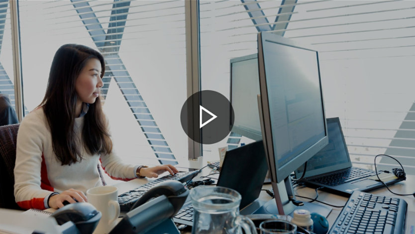 A person working at a dual-monitor work station