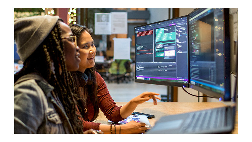 Two female developers working and collaborating in an enterprise office.