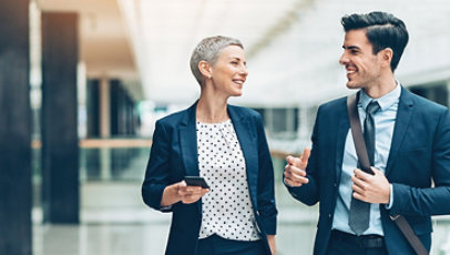 Two businesspersons walking together and talking.