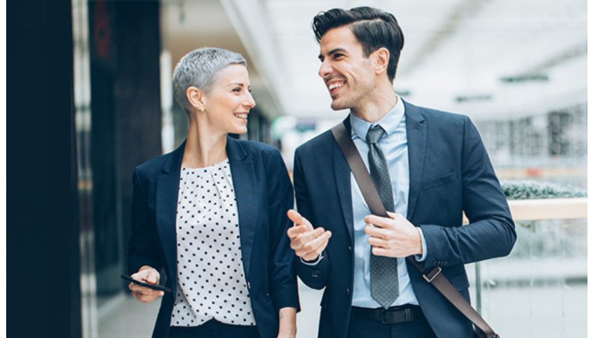 Two business people walking together and talking.