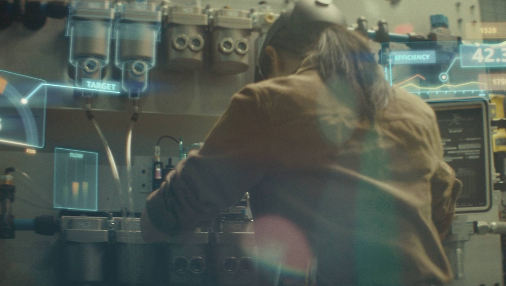 A scientist works on advanced equipment displaying digital data, focusing intently in a lab environment.