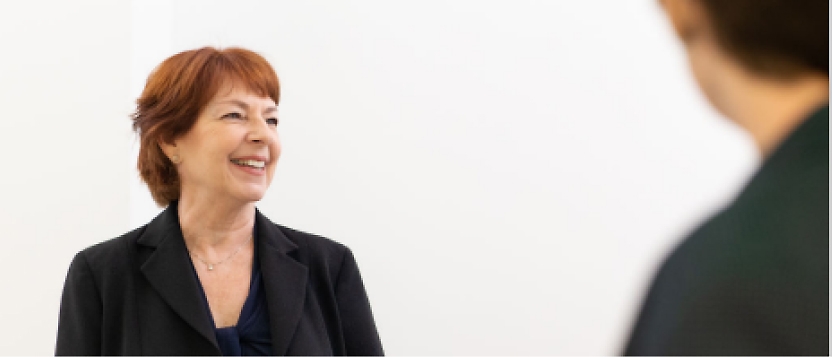 A woman is talking to another woman in a business suit.