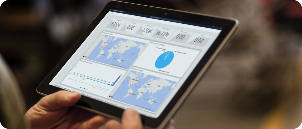 Close-up of hands holding a tablet displaying various analytics dashboards