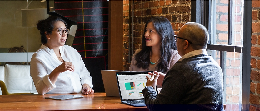 Group of people discussing while sitting and some of them are using a laptop.