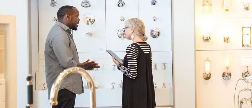 A man and woman talking in a showroom.