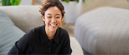 A smiling woman sitting on a couch.