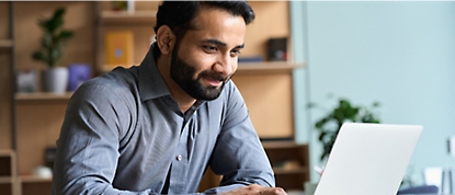 A man looking to a laptop with smiling face