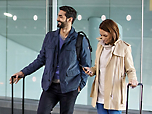 Мужчина и женщина с багажом в аэропорту.