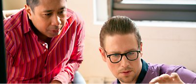 Two men looking at a computer screen.