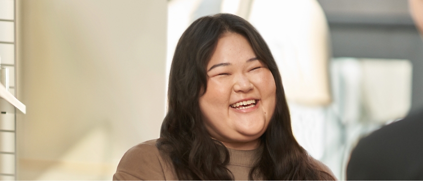 An asian woman laughing with another woman.