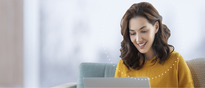 A woman sitting on a couch using a laptop.