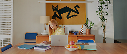 A woman working at a desk with a laptop.