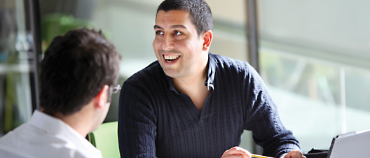 A person laughing while sitting at a table