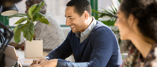 A person smiling while watching laptop