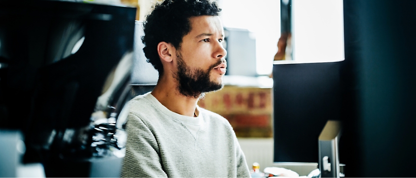 A man sitting in front of a computer screen.