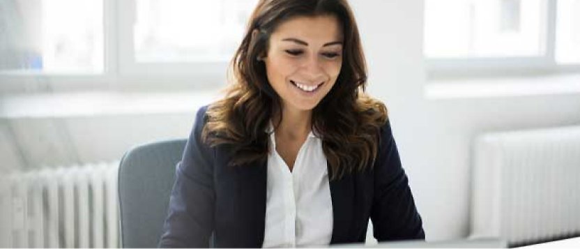 Eine lächelnde Frau, die in einem Büro sitzt