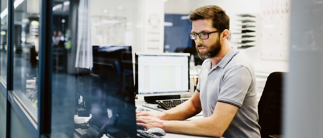 Homem a trabalhar num computador num escritório.