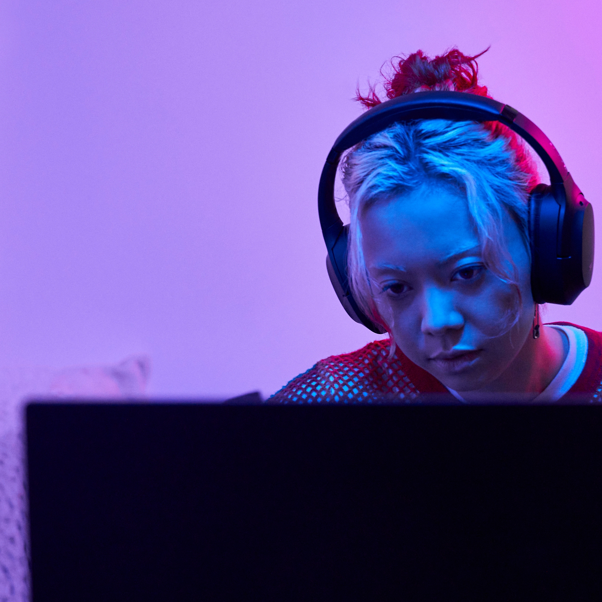 A woman working on laptop with headphones