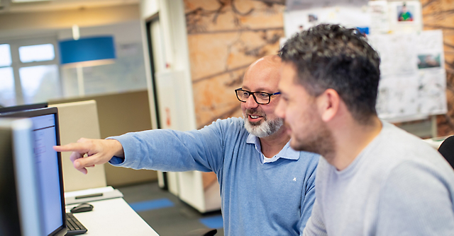 Two employees working together at a desk