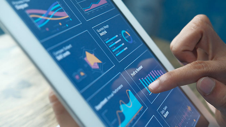 A hand using a tablet displaying 8 graphs