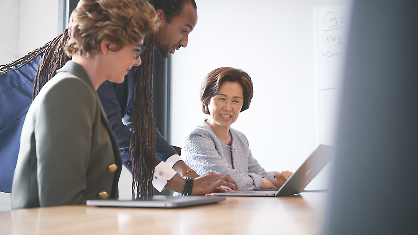 Three persons in an office and discussing over a laptop