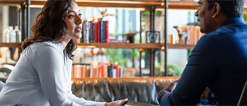 Two people having a conversation in a library