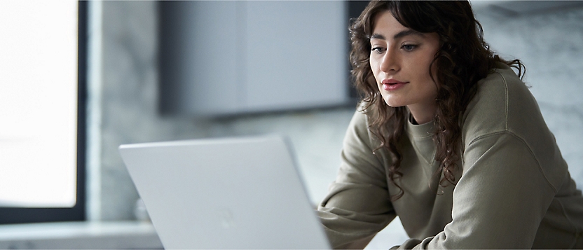 A girl with curly hair watching her laptop