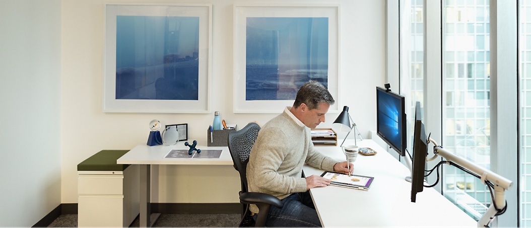 A man is sitting on chair and watching a tablet