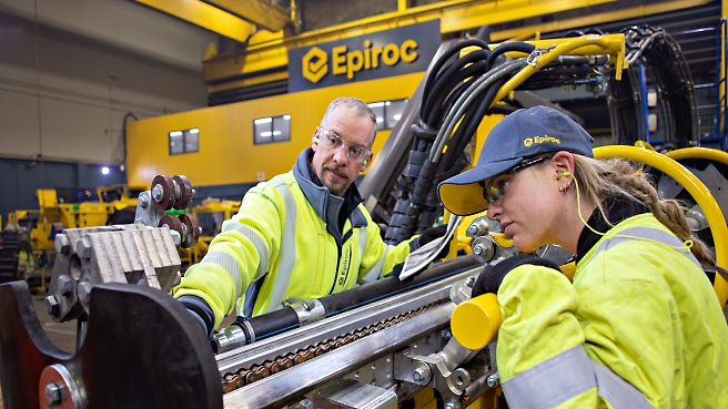 A person and another person working on a machine