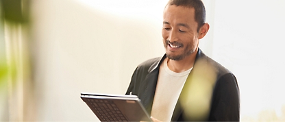 A person smiling while holding a computer