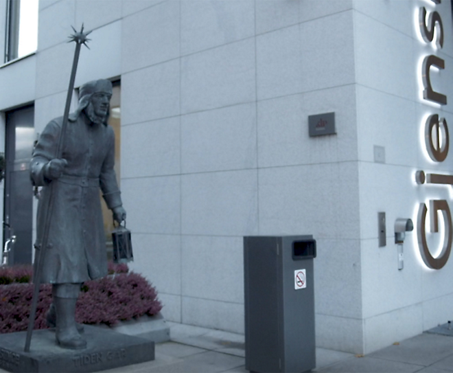 A statue of a man standing in front of a building.