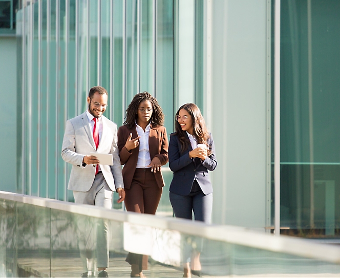 Grupo de personas caminando en una oficina con ropa formal.