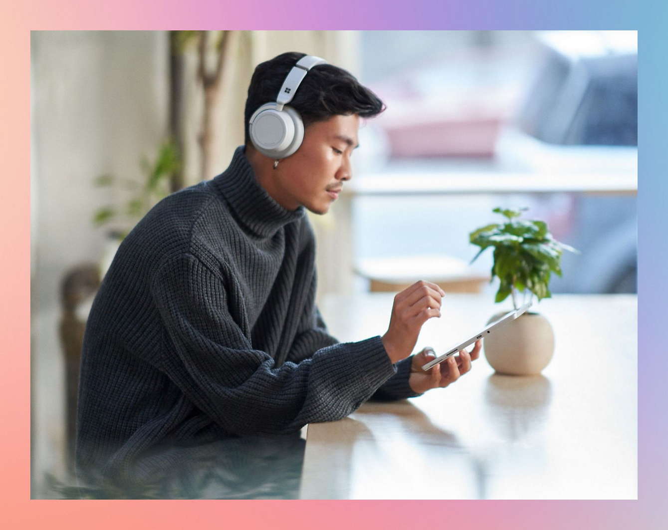 A person wearing headphones and using a tablet.