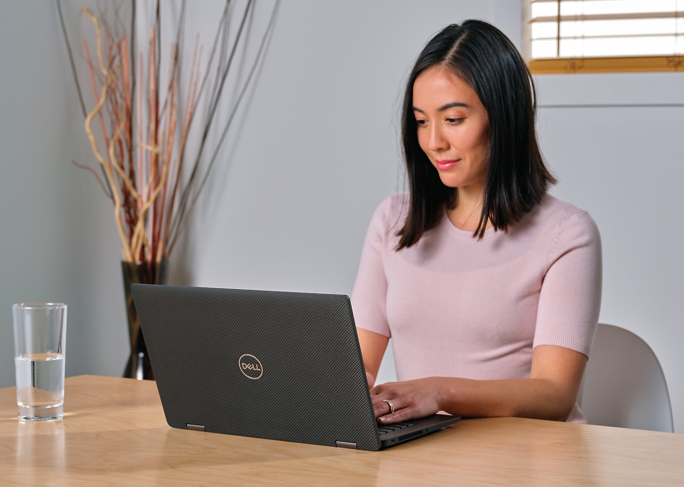 A woman sitting at a table using a laptop.