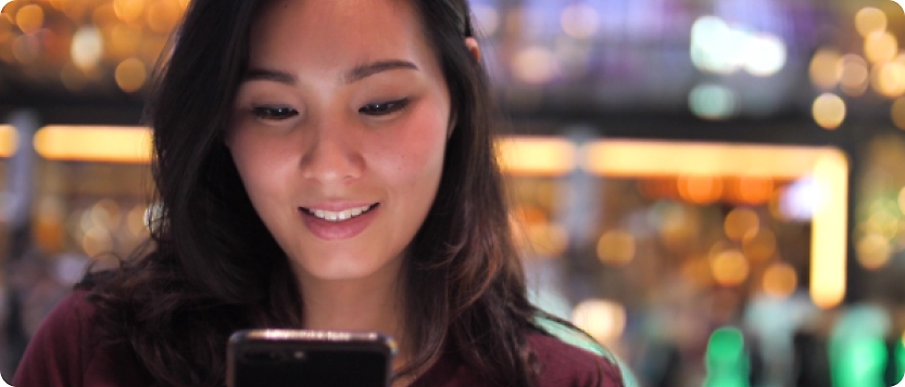 A young asian woman looking at her cell phone.