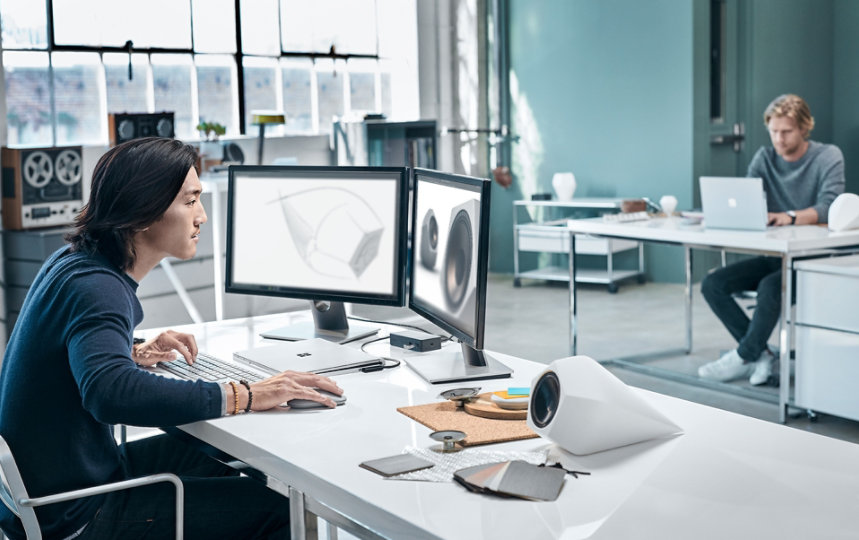  Un hombre utiliza su ratón Surface Mouse con un dispositivo Windows en un escritorio.