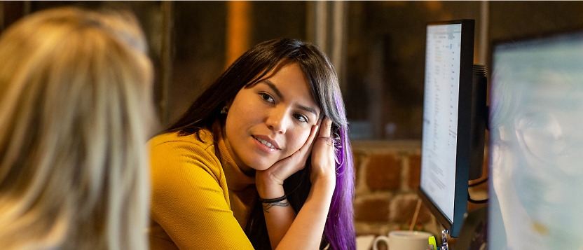 Two women sitting in front of a computer.