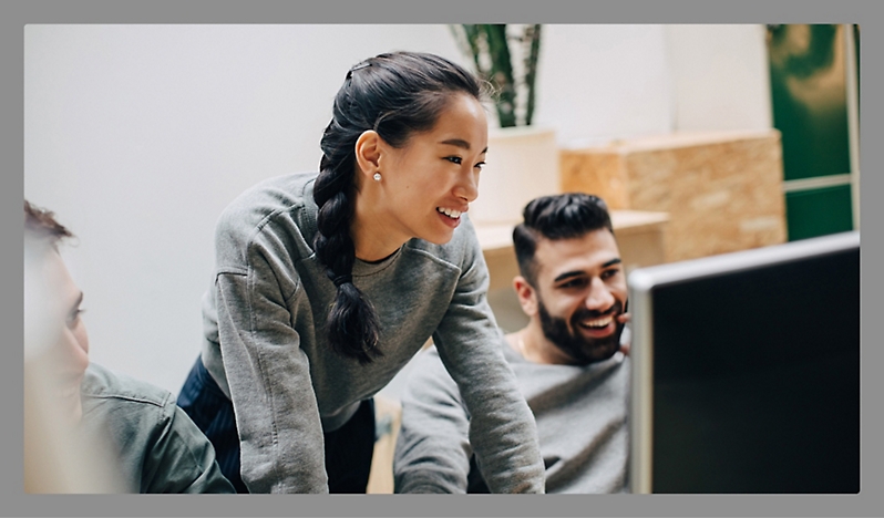 Three people discussing something in a office room with smiling face