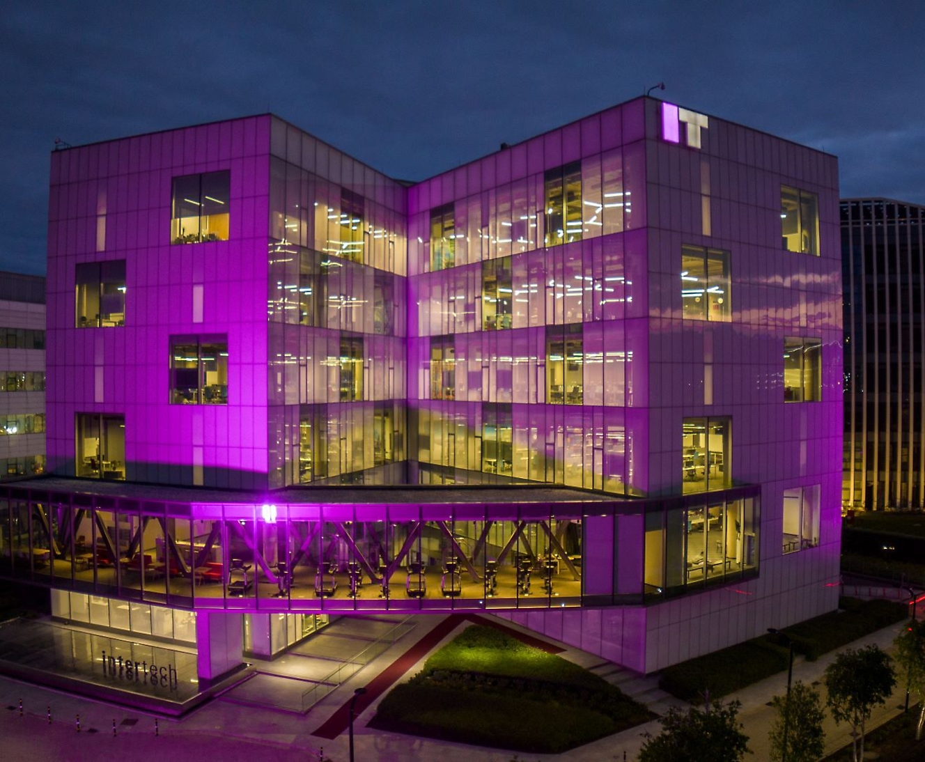 A building with purple lights with IT logo on the top.