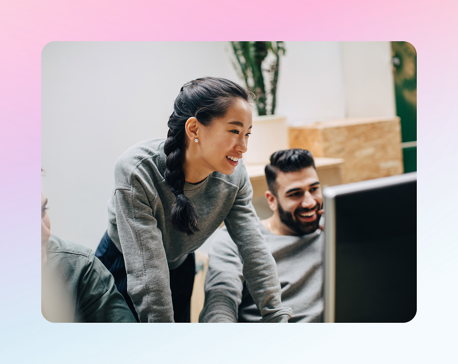 Three people looking at a computer and smiling