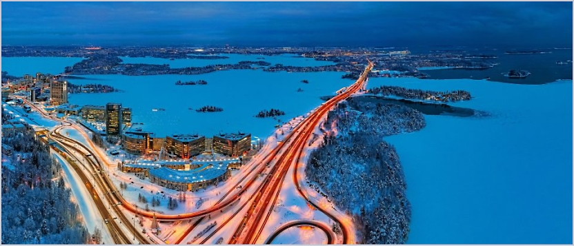 En flygbild av ett stadslandskap med upplysta vägar som vindlar genom snötäckta landskap