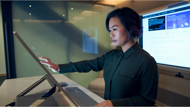 A person using a large touchscreen monitor