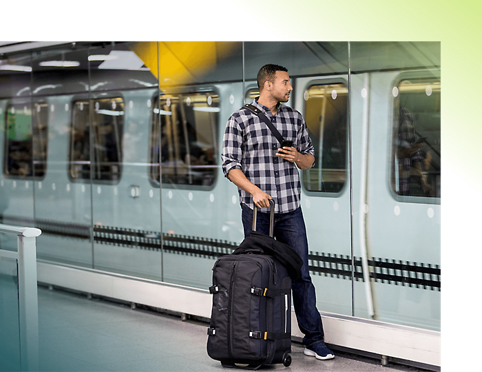 A person with luggage standing in front of metro