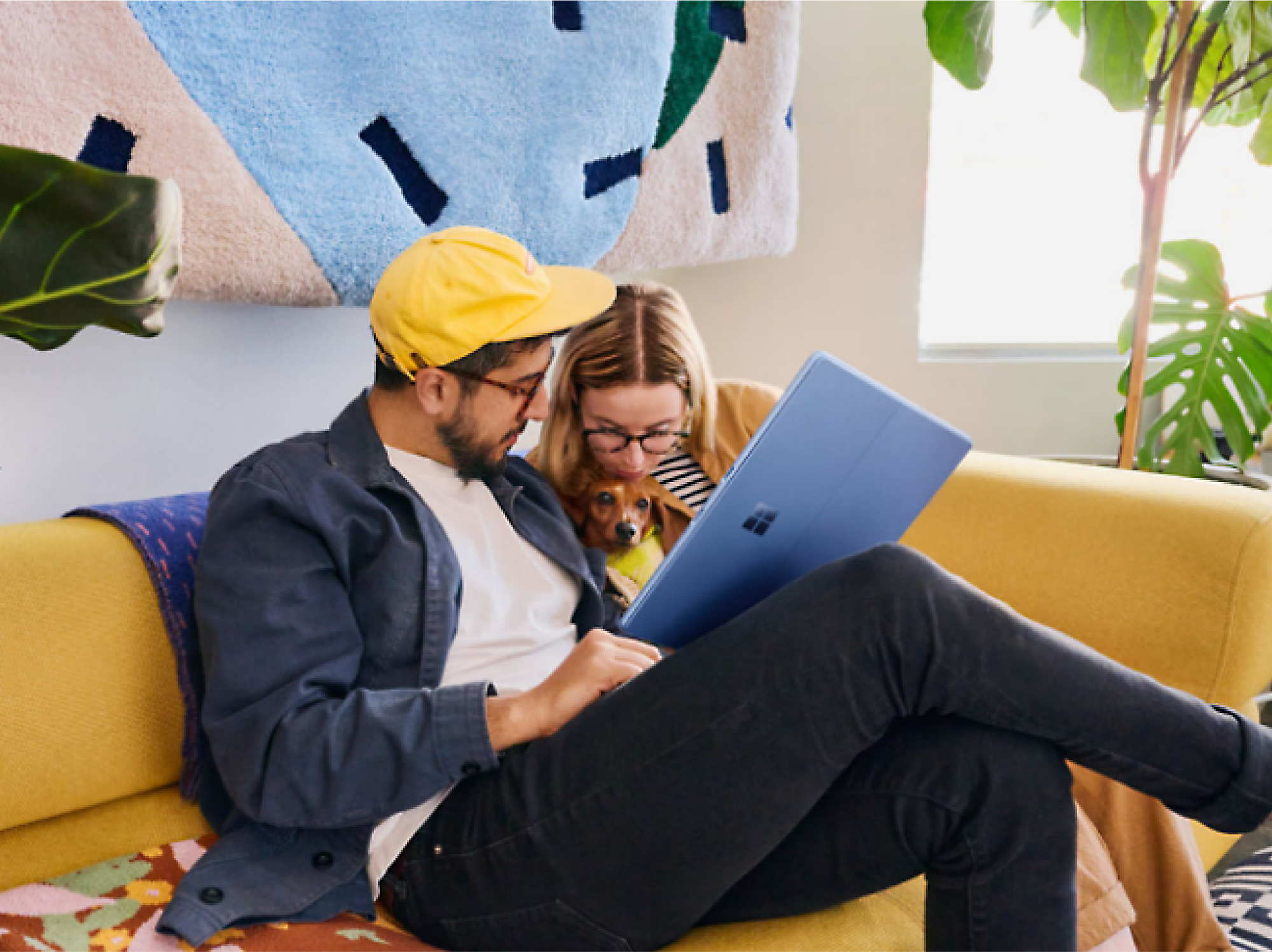 Twee personen met een computer die op een bank zitten