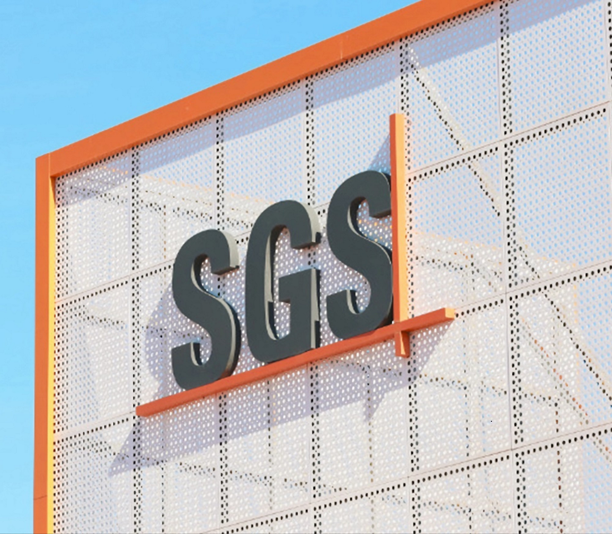 A building with a perforated metal facade displays the letters "SGS" 