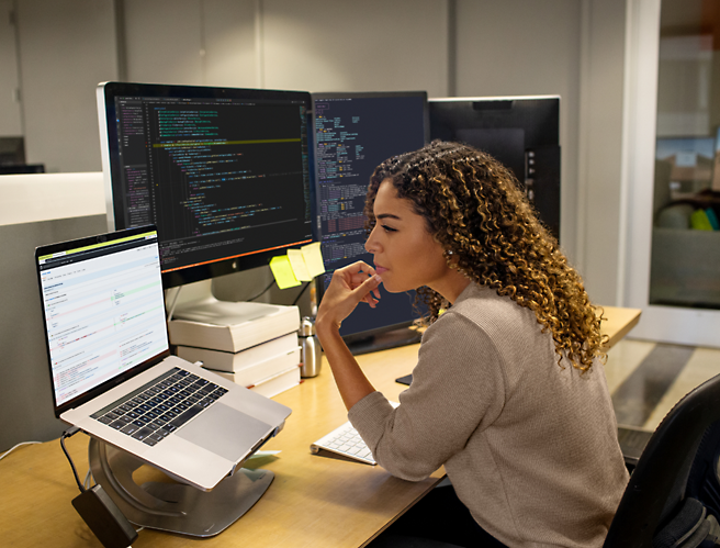 A woman sitting at a desk looking at a computer screen