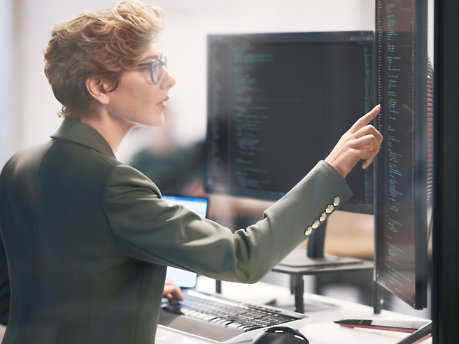 A woman is pointing at a computer screen